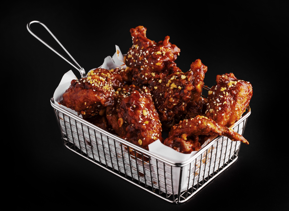 high-angle-shot-basket-delicious-fried-chicken-with-hot-sauce-black-surface El-Diablo -baked-chicken-wings-with-sauce